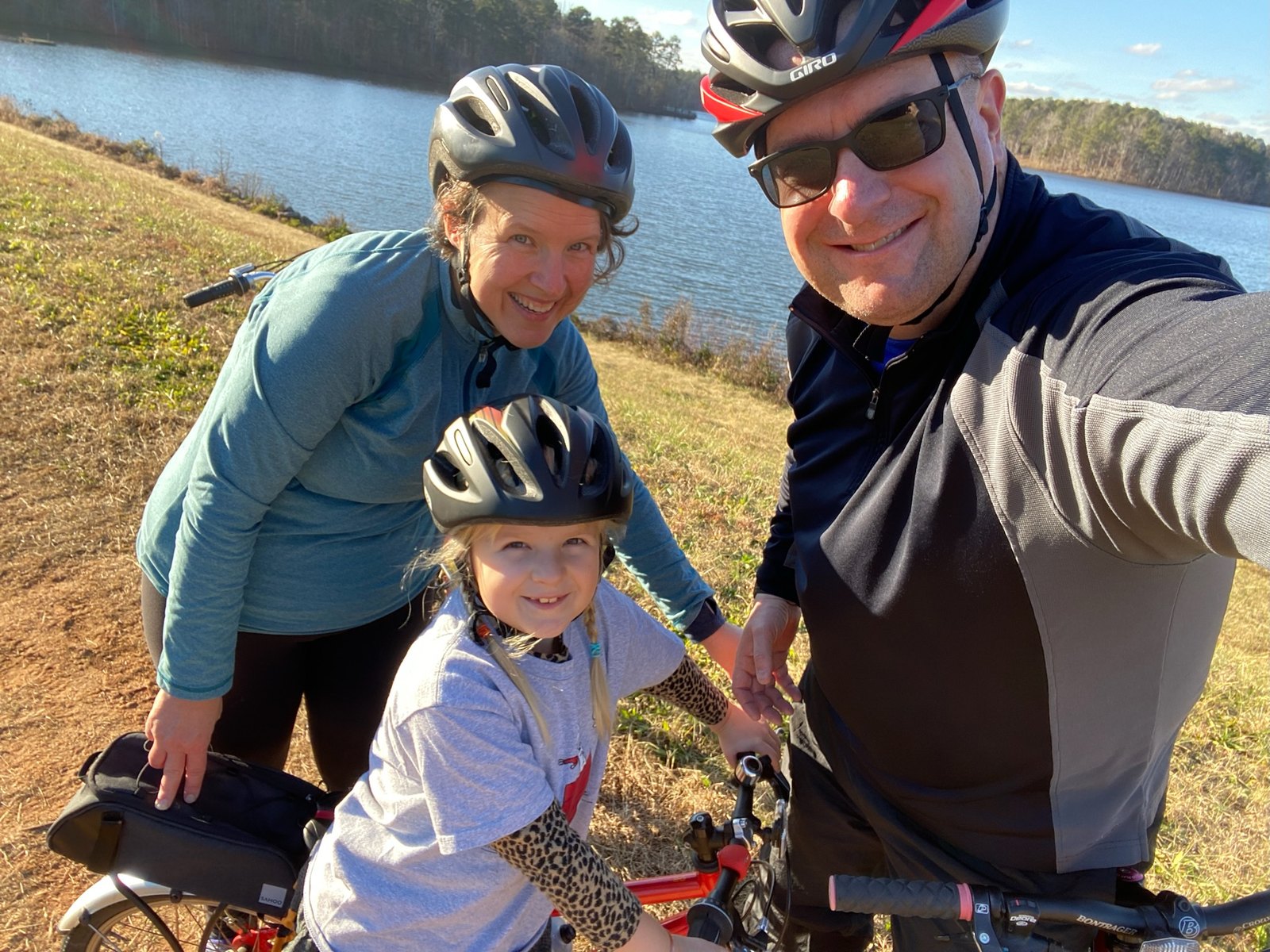 Family bike ride beside a lake
